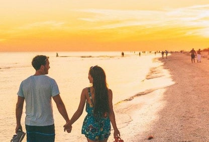 couple strolling on a sanibel island beach in florida at sunset